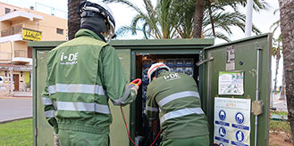 Dos operadores de I-de en mantenimiento de una caja de luz