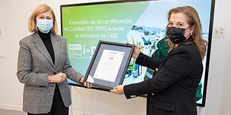 Dos mujeres enseñando a cámara el certificado de AENOR